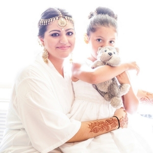 Bride getting ready and holding daughter with stuffed animal