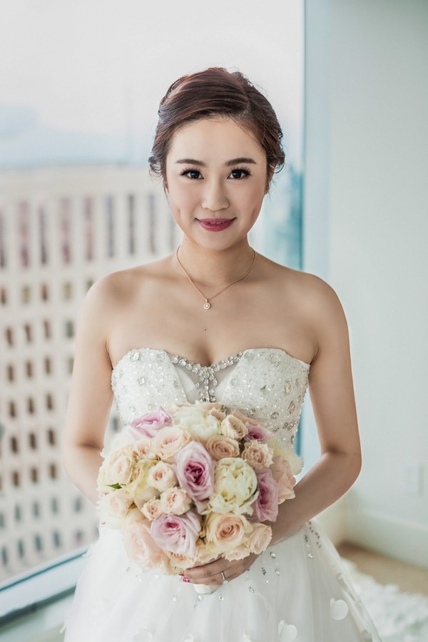 Elegant bride holding classic bouquet of pastel roses