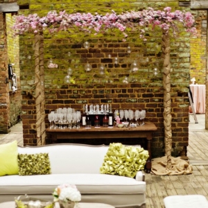 Outdoor vintage lounge area with bar and floral arch