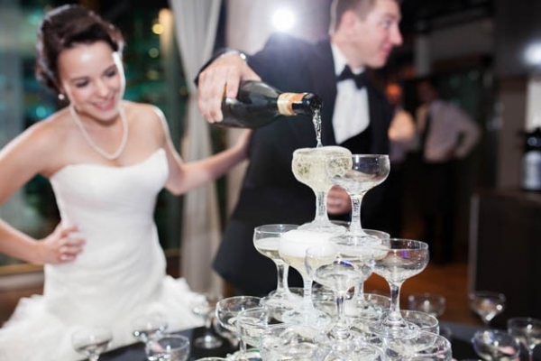 Newlywed couple pouring a Champagne tower