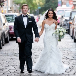 Bride and groom walking on cobblestone street in New York