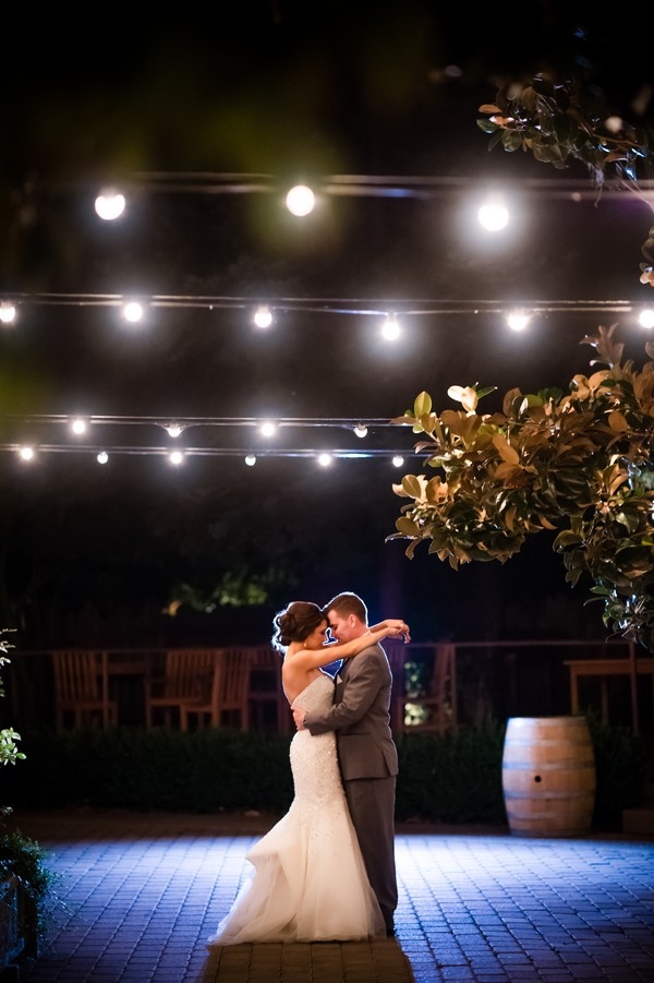 Romantic photo of bride and groom under cafe lights