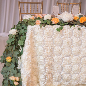 A Sweetheart Table with Centerpiece Garland and Rosette Linen