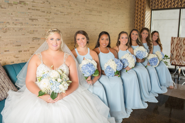 Bridesmaids in light blue dresses with hydrangea bouquets
