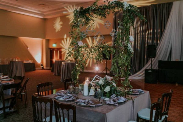 Wedding table with hanging greenery and geometric shapes