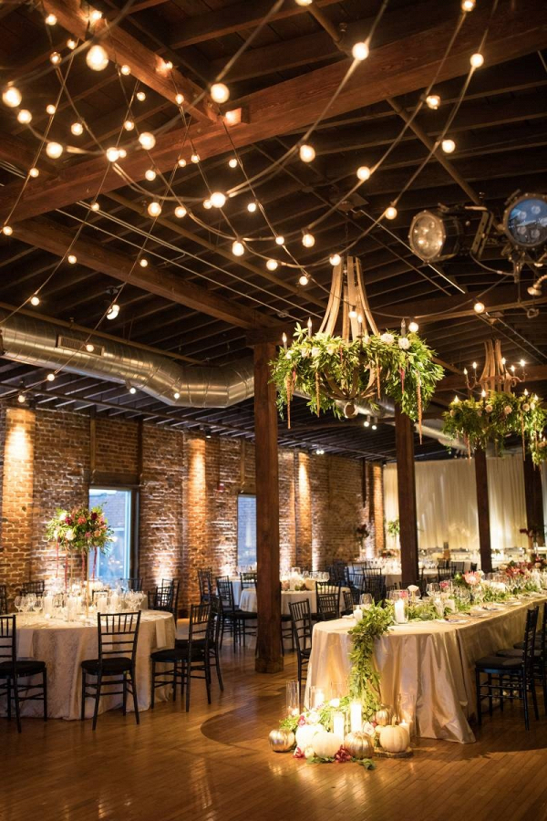 Industrial wedding venue with floral covered chandeliers