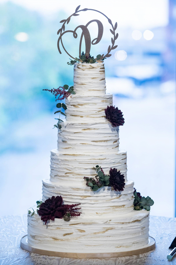 Gold flaked wedding cake with monogram topper