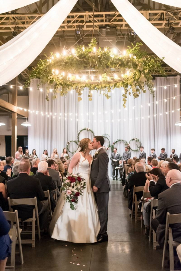 Barn wedding ceremony with draping and floral chandeliers