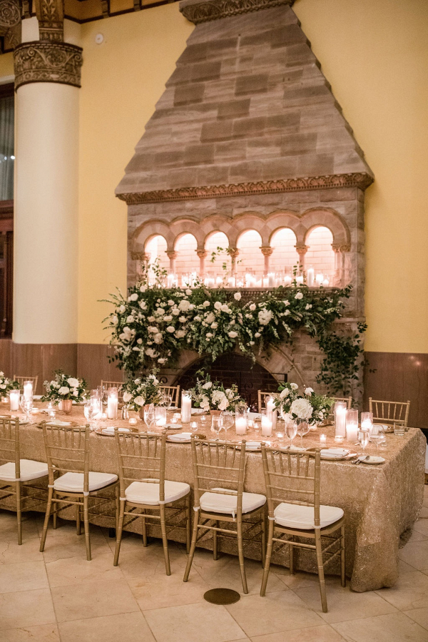Elegant white wedding reception with floral covered fireplace
