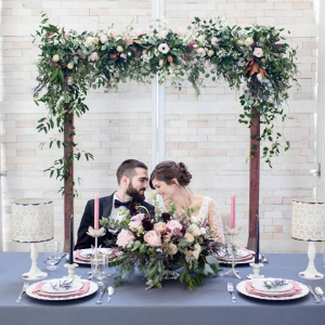 Sweetheart table with floral wedding arch