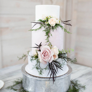 Tall white wedding cake with fresh flowers 