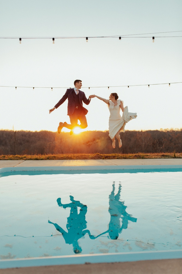 Bride and groom jumping in pool