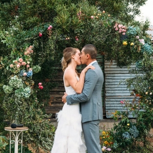 Newlyweds First Kiss Under Floral Arch