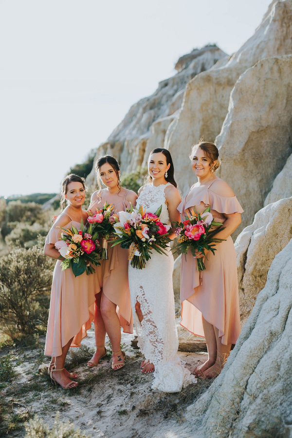 Bridesmaids in peach high-low gowns