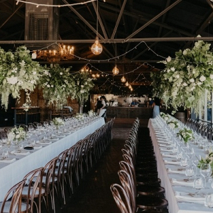Wedding reception with long tables and suspended florals
