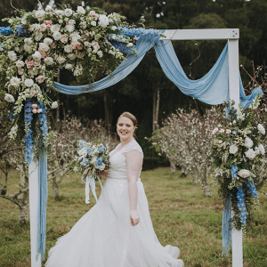 Lush floral and draping ceremony arch