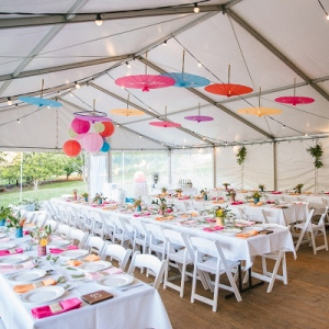 Colorful tented wedding reception with hanging umbrellas