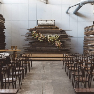 Industrial ceremony backdrop with wood planks and floral installation 