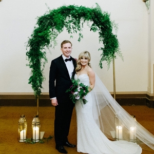 Newlyweds With Greenery Arch