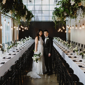 Modern black and white wedding reception with hanging greenery