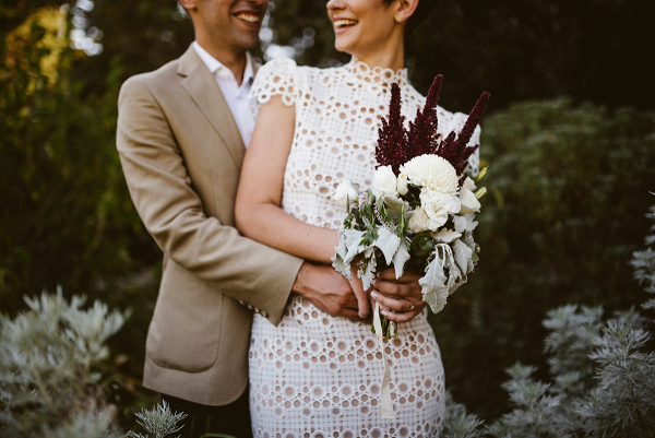 Bride in modern lace dress with small bouquet