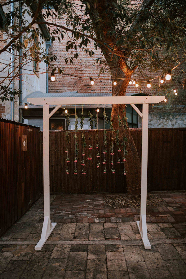 Nighttime ceremony with hanging flower arch
