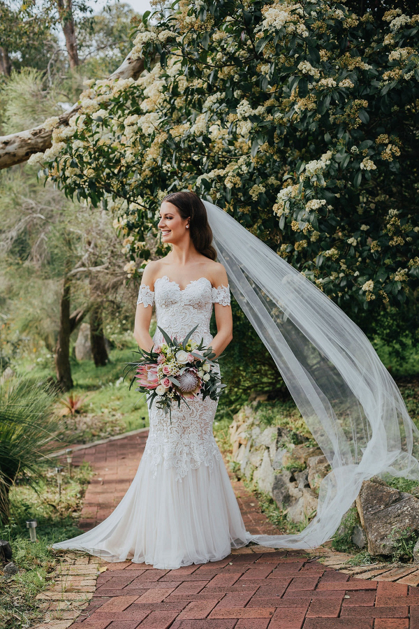 Bride in off the shoulder lace gown with cathedral veil