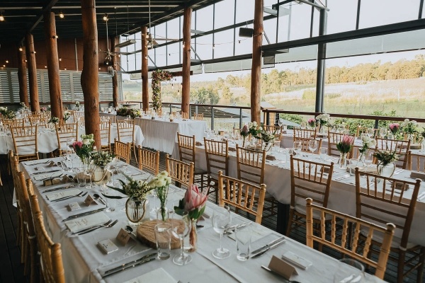 Wedding reception with long tables and protea floral centerpieces