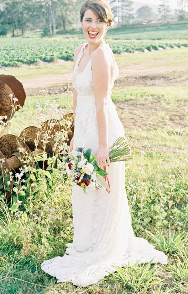 Bride in Strawbwerry Field With Red Bouquet