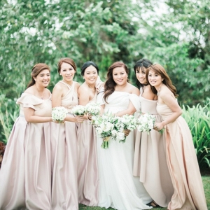 plus size bride in off the shoulder gown with bridesmaids wearing blush