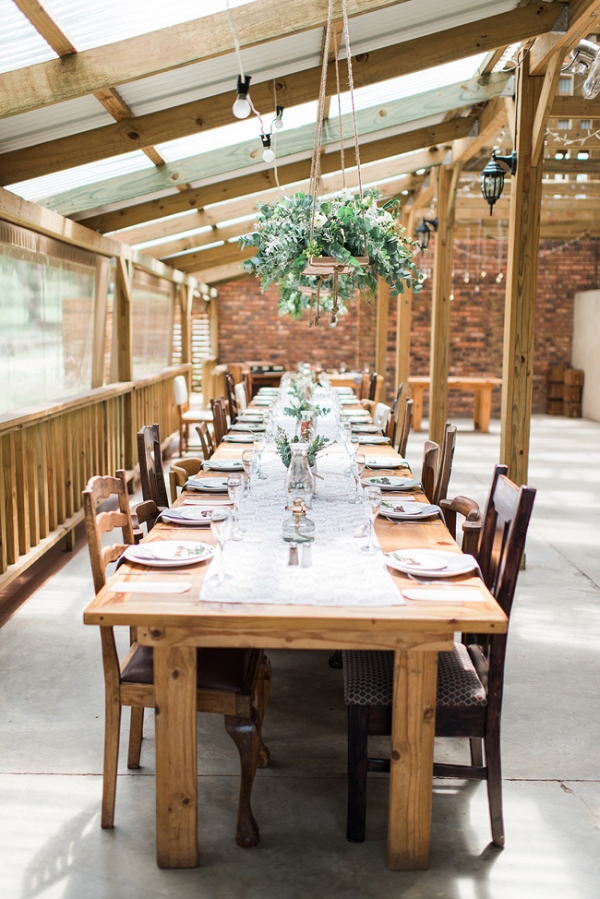 Long wooden tables with hanging greenery