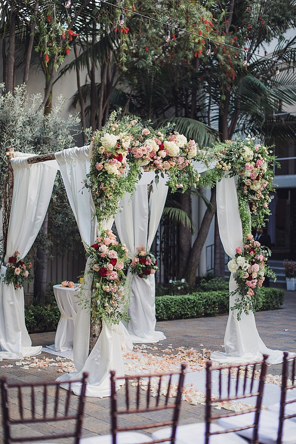 Draping and floral covered ceremony arbor