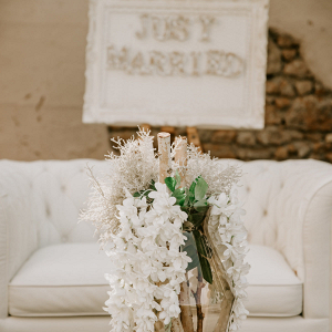 Glass vase with a white couch and a just married sign in the background