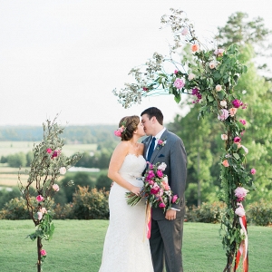 Unclosed, asymmetrical wedding arch with pink peonies and greenery