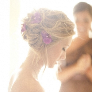 Beautiful bridal hairdo adorned with purple orchids