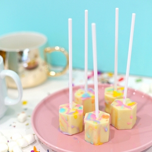 Color-splattered white hot chocolate on a stick
