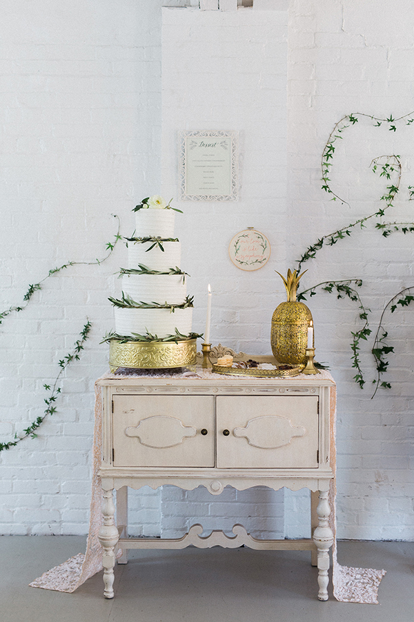 Elegant cake table framed by ivy wall art