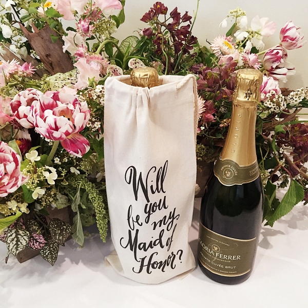 A calligraphed wine bottle tote for asking your best friend to be your maid of honor