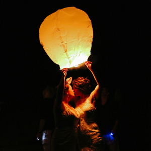 Two brides releasing chinese lanterns at a wedding 