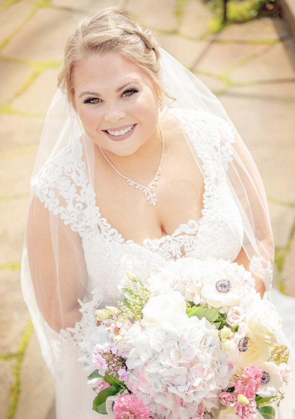 Bride in lace wedding dress with white and blush bouquet