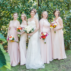 Bridesmaids in mismatched blush and cream dresses