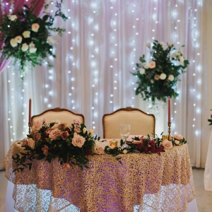 Sweetheart table with string light backdrop