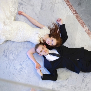 Bride and groom lying on a marble floor
