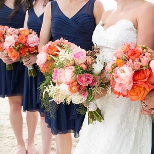 Navy blue bridesmaid dresses and coral bouquets