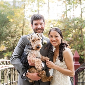 Bride and groom holding their dog
