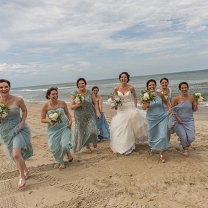 Bridal party running on the beach