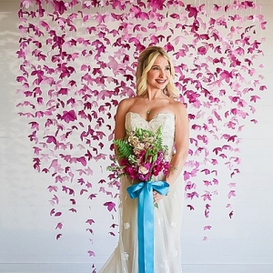 Bride in front of paper flower backdrop