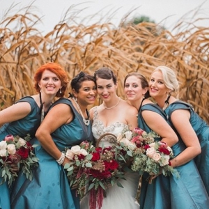 Bridesmaids in teal dresses in wheat field